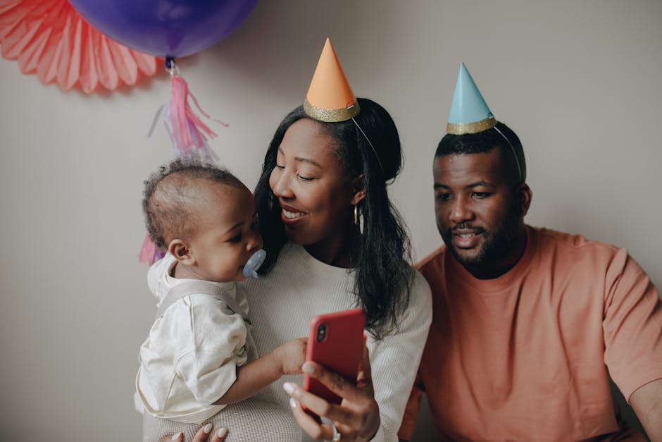 Family enjoying a birthday celebration with balloons and party hats.